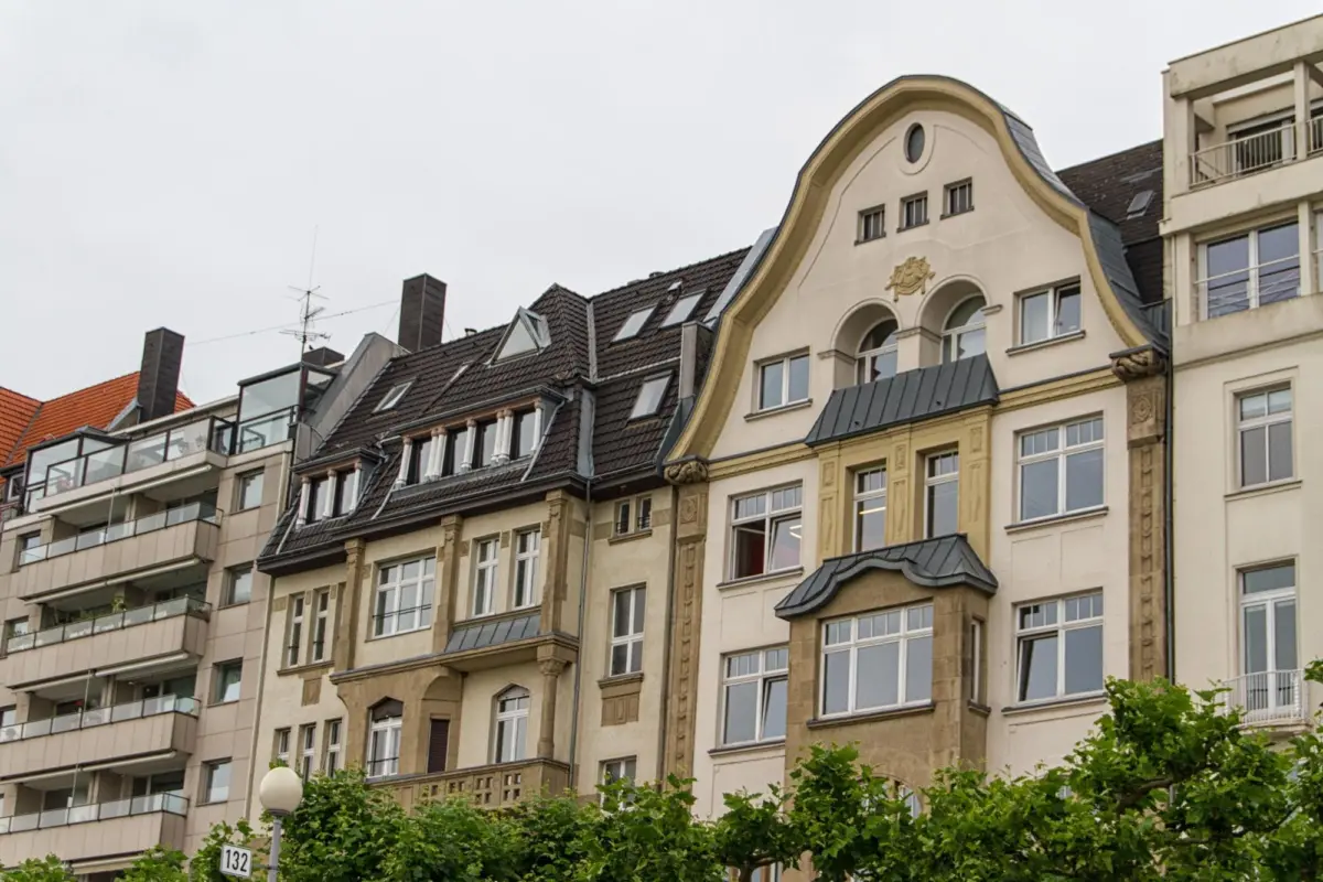 Reihe mehrgeschossiger Wohnhäuser mit Altbau- und Nachkriegsfassaden